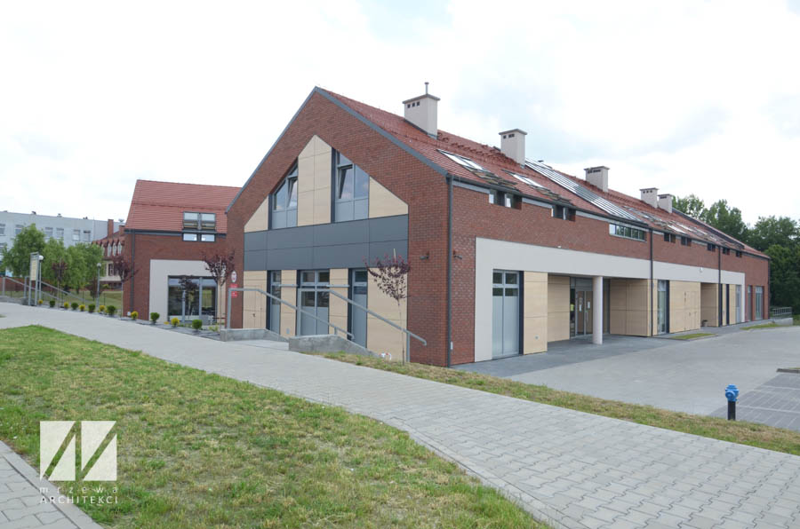 Obrazek przedstawia budek Gminnego Centrum Społeczno-Kulturalnego, gdzie mieści się siedziba Ośrodka Pomocy Społecznej w Sośnicowicach. Zdjęcie od strony wejścia bocznego.